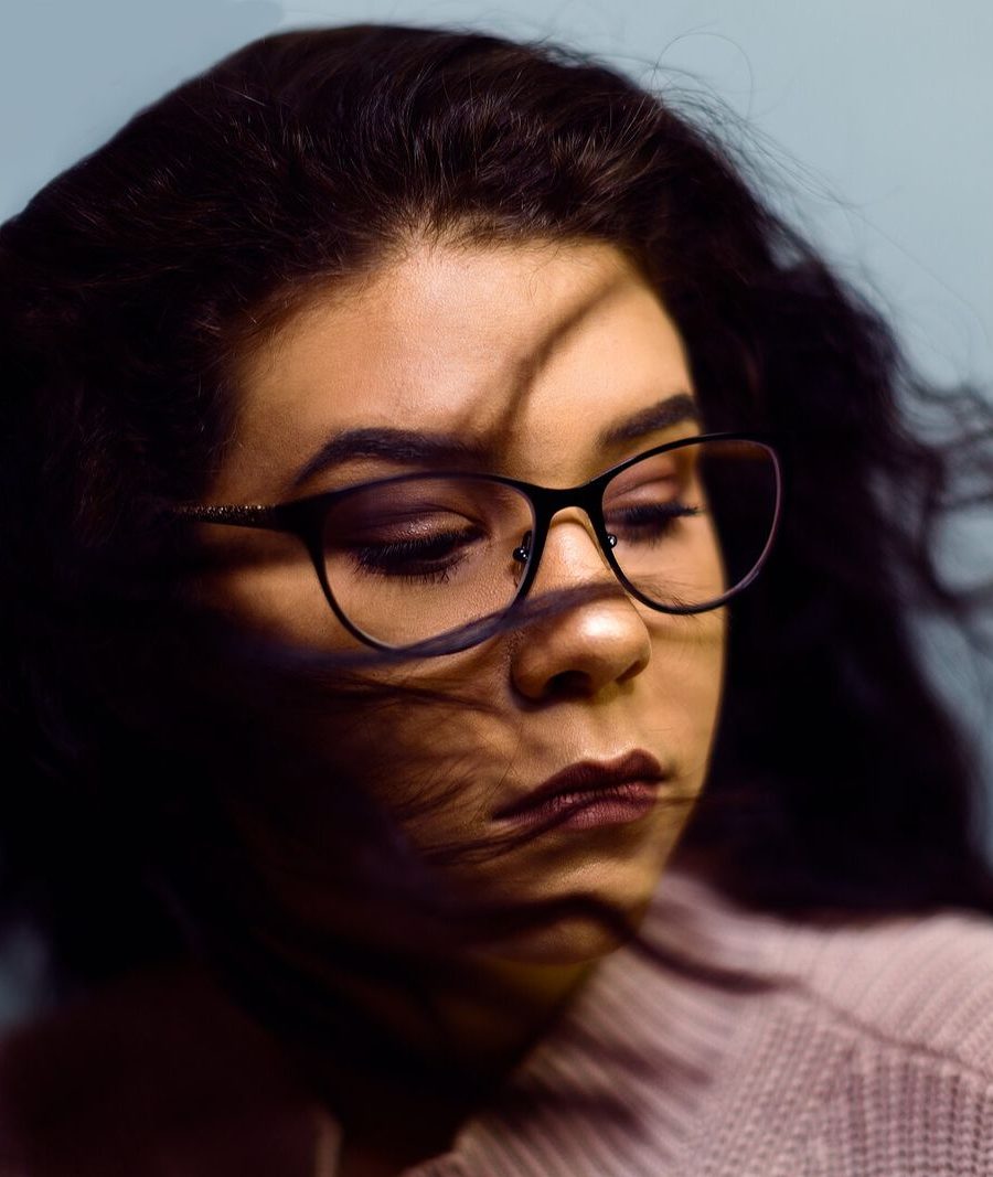A portrait with dark curly hair and glasses