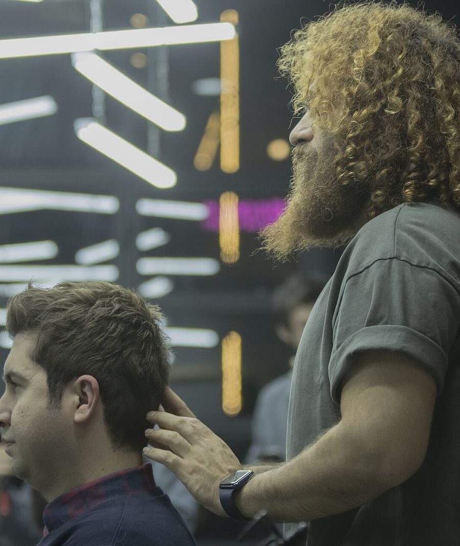A stylist with curly hair at work